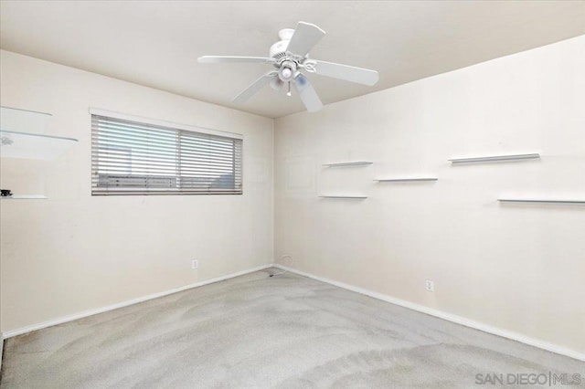 carpeted spare room with ceiling fan