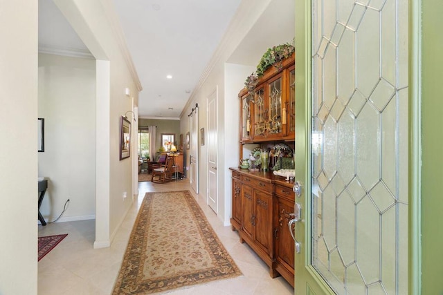 corridor with light tile patterned floors and crown molding