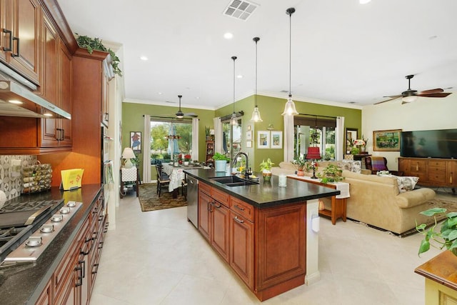 kitchen with sink, crown molding, hanging light fixtures, an island with sink, and stainless steel appliances