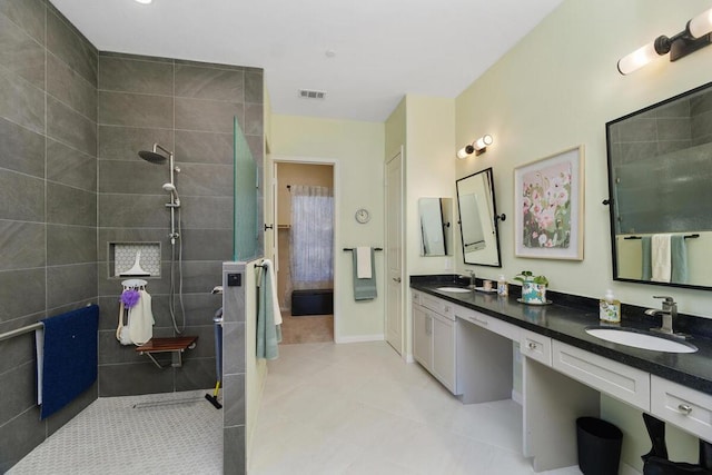 bathroom with vanity and tiled shower