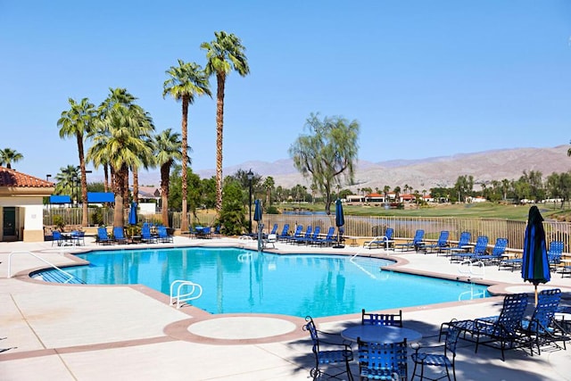 view of pool featuring a patio area and a water and mountain view