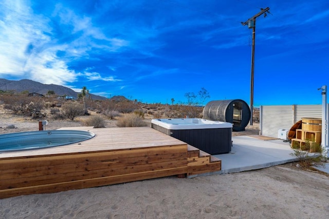 exterior space with a jacuzzi and a mountain view