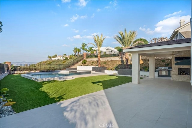 exterior space with a fenced in pool, a patio area, and exterior kitchen