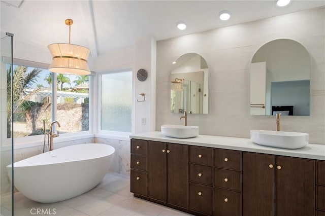 bathroom featuring vanity, a tub, and tile walls