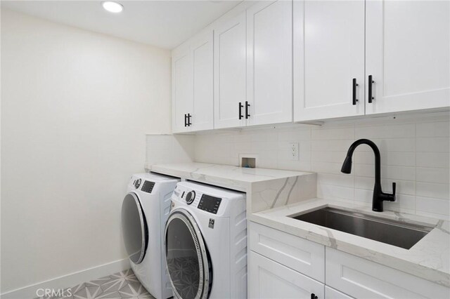 washroom with cabinets, sink, and independent washer and dryer