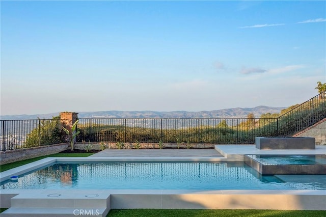 view of pool with an in ground hot tub and a mountain view