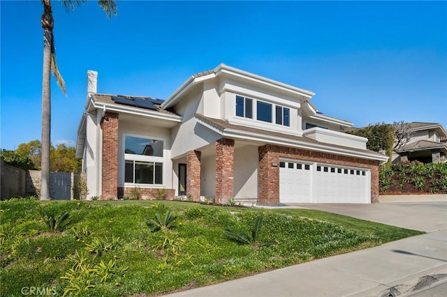 view of front of home with a garage, a front yard, and solar panels