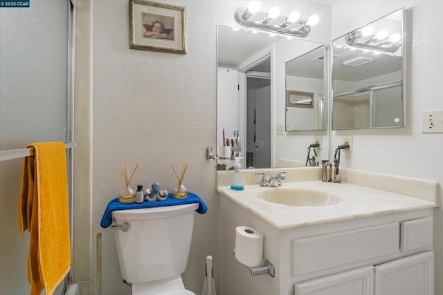 bathroom featuring vanity, toilet, and walk in shower