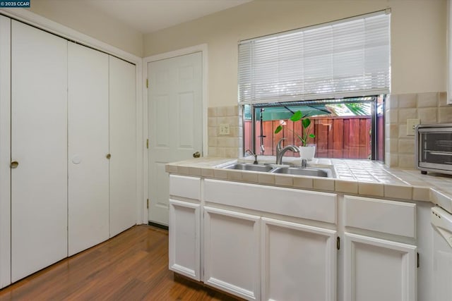 kitchen featuring sink, tile countertops, dark hardwood / wood-style floors, and white cabinets