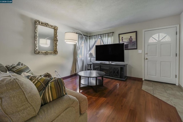 living room with wood-type flooring and a textured ceiling