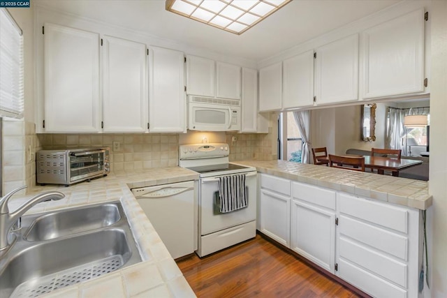 kitchen featuring white cabinetry, tile countertops, and white appliances