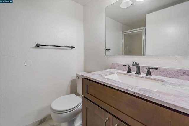 bathroom featuring vanity, an enclosed shower, and toilet