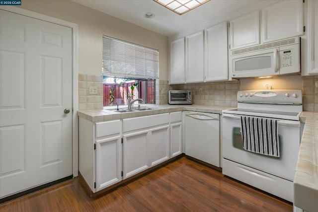 kitchen featuring dark hardwood / wood-style floors, tile countertops, sink, white cabinets, and white appliances