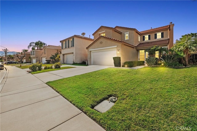 mediterranean / spanish-style home with a garage and a lawn