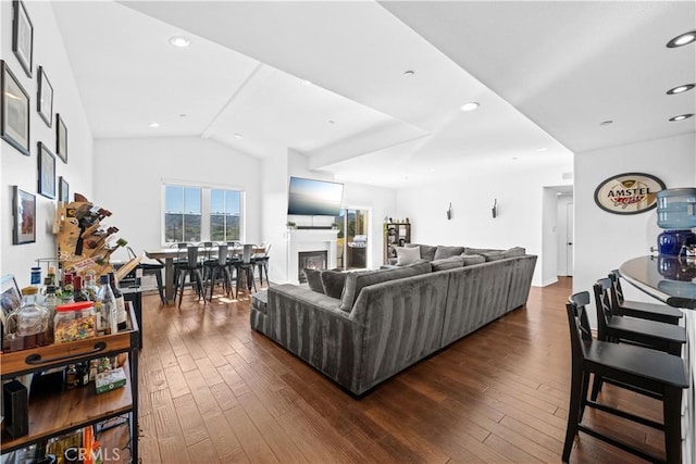 living room with dark hardwood / wood-style flooring and vaulted ceiling