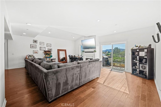 living room featuring hardwood / wood-style flooring and vaulted ceiling