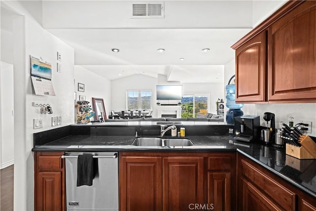 kitchen featuring sink, vaulted ceiling, dishwasher, kitchen peninsula, and dark stone counters