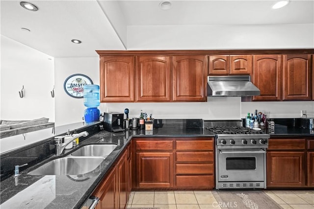 kitchen featuring sink, range hood, light tile patterned flooring, designer stove, and dark stone counters