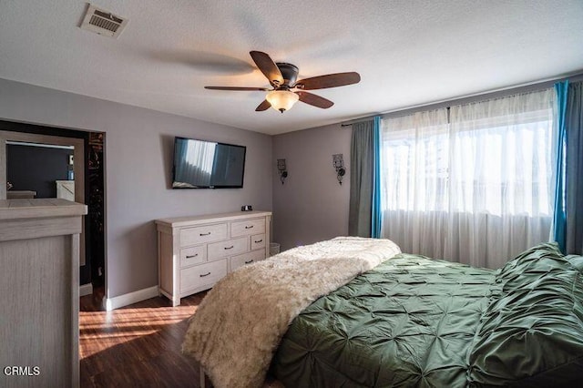 bedroom featuring ceiling fan, light hardwood / wood-style flooring, and a textured ceiling