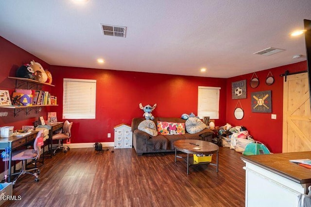 living room featuring a barn door and dark hardwood / wood-style flooring