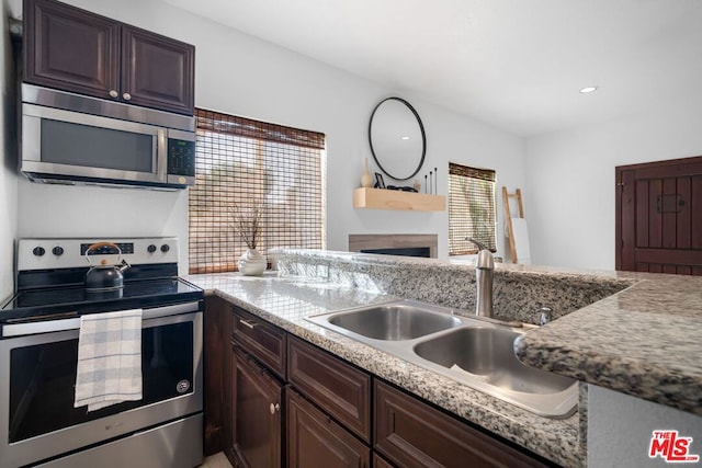 kitchen featuring stainless steel appliances, sink, and dark brown cabinets