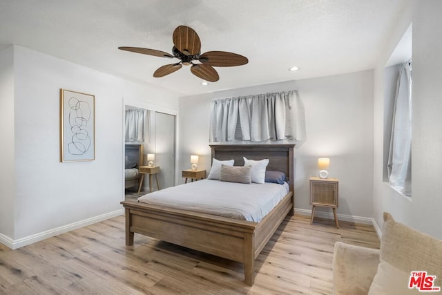 bedroom featuring light hardwood / wood-style flooring, a closet, and ceiling fan