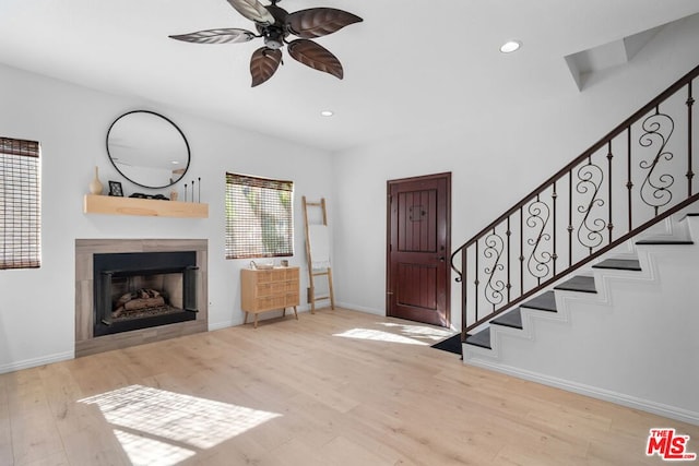 foyer featuring a tile fireplace, ceiling fan, and light hardwood / wood-style floors