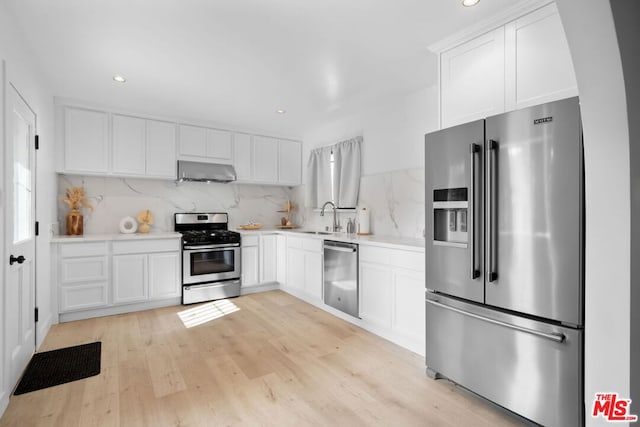 kitchen featuring stainless steel appliances, extractor fan, sink, and white cabinets