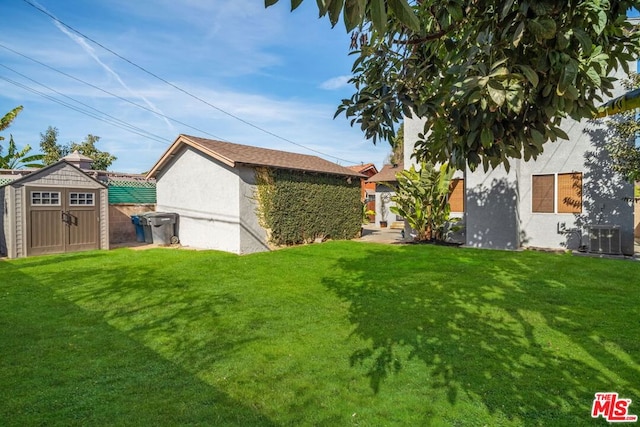 view of yard with central AC and a shed