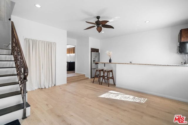 interior space with ceiling fan and light hardwood / wood-style floors