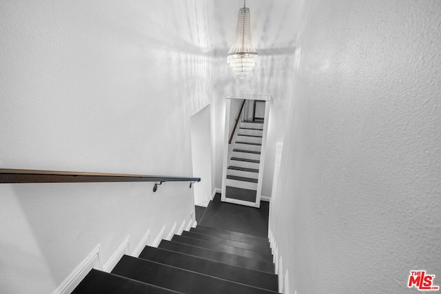 stairs with a notable chandelier and wood-type flooring