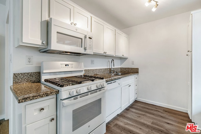 kitchen featuring sink, white cabinetry, white appliances, dark stone counters, and hardwood / wood-style floors