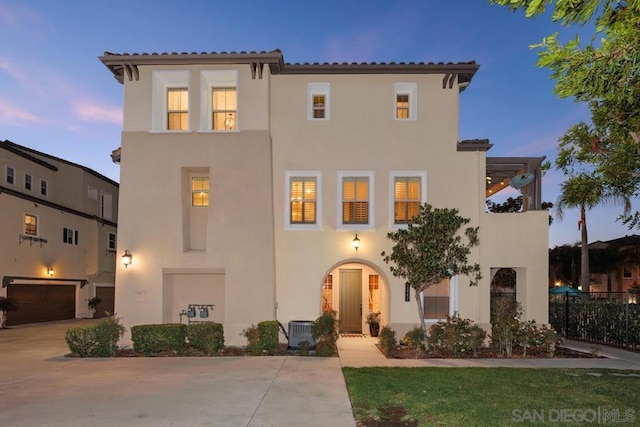 mediterranean / spanish-style home with a garage and central air condition unit