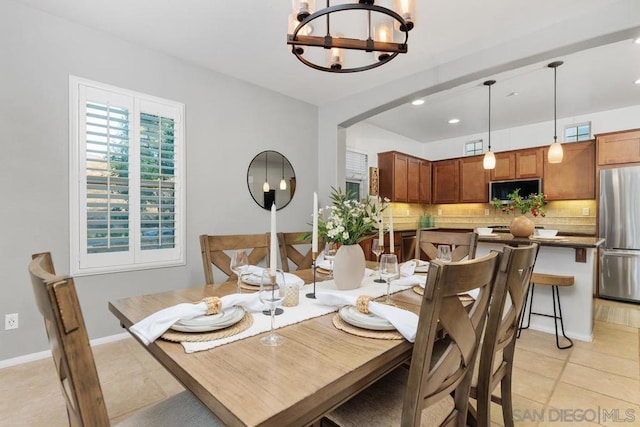 tiled dining area featuring a notable chandelier