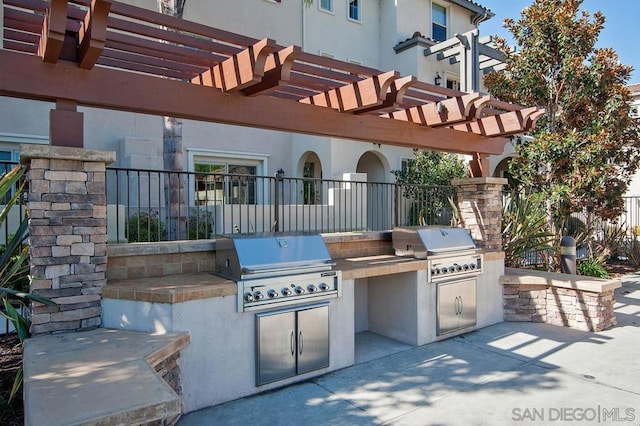 view of patio with area for grilling, a grill, and a pergola