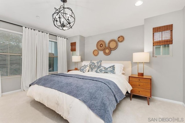 bedroom featuring light carpet and a chandelier