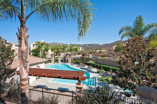 view of swimming pool featuring a mountain view and a patio