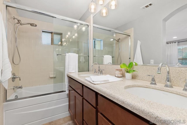 bathroom featuring tile patterned flooring, vanity, and combined bath / shower with glass door