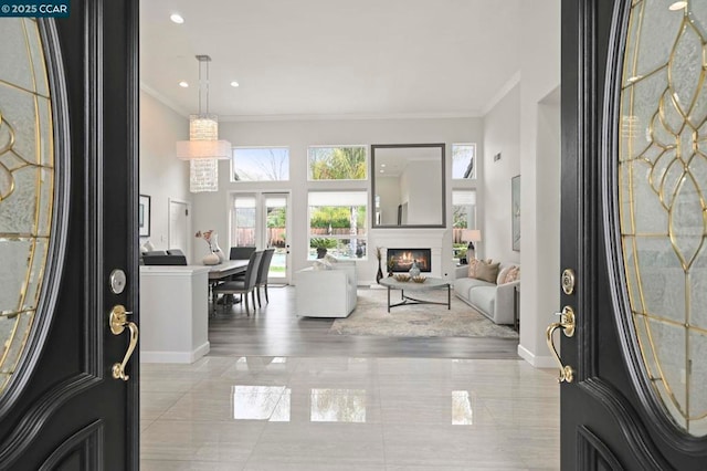 entryway featuring ornamental molding and a high ceiling