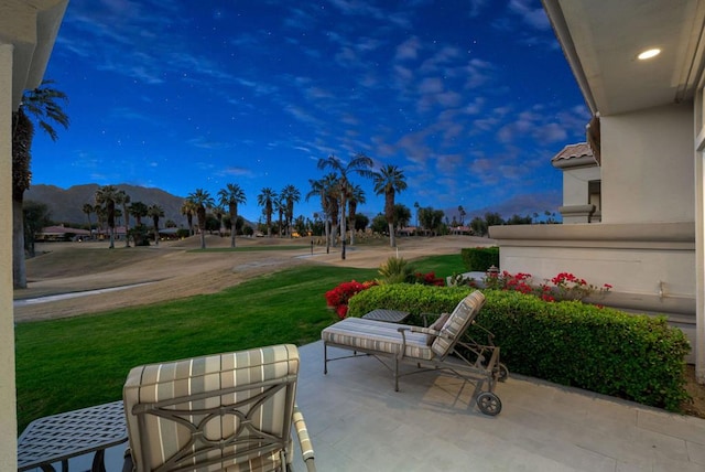 patio terrace at dusk featuring a yard