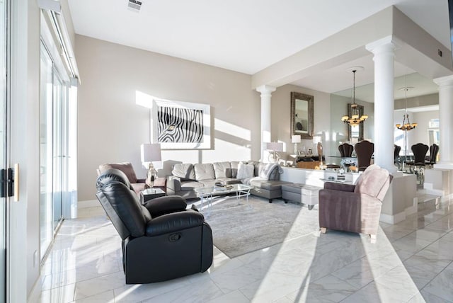 living room with decorative columns, a healthy amount of sunlight, and a notable chandelier