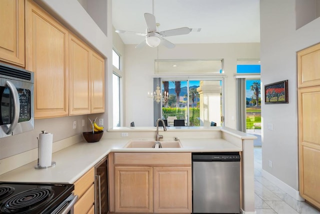 kitchen with sink, light brown cabinets, kitchen peninsula, and appliances with stainless steel finishes