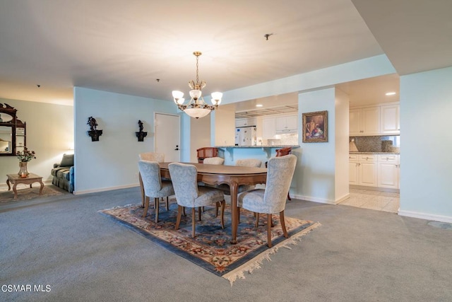 carpeted dining room featuring an inviting chandelier