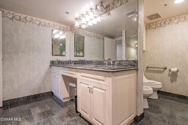 bathroom with a bidet, vanity, and toilet