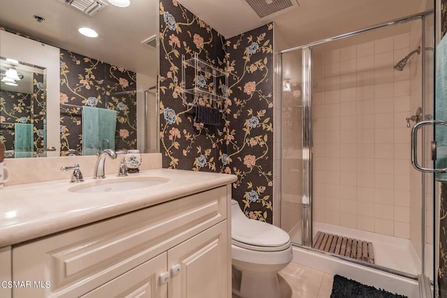 bathroom featuring a shower with door, vanity, and toilet