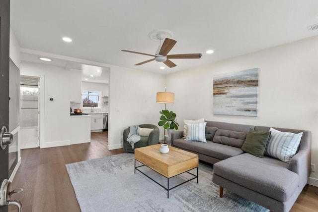 living room featuring dark hardwood / wood-style floors, sink, and ceiling fan