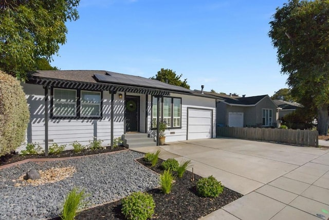 ranch-style home featuring a garage and solar panels