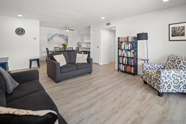 living room featuring ceiling fan and light wood-type flooring