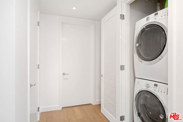 washroom featuring stacked washer / drying machine and light hardwood / wood-style flooring