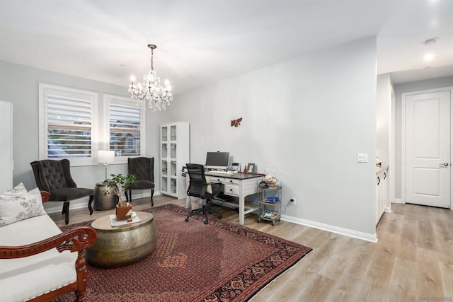 office space with an inviting chandelier and light hardwood / wood-style floors